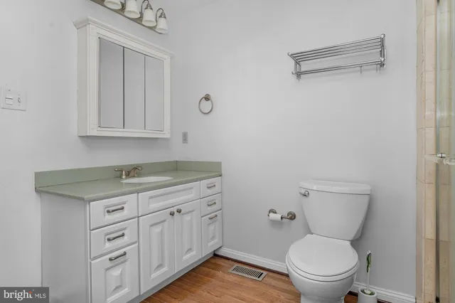 a bathroom with a granite countertop toilet a sink and a mirror