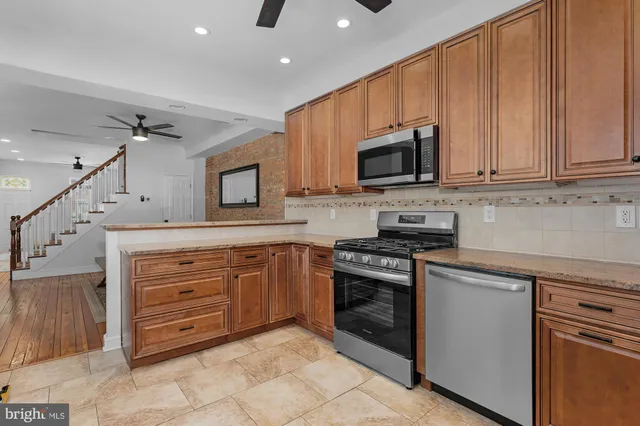 a kitchen with stainless steel appliances granite countertop a stove microwave and cabinets