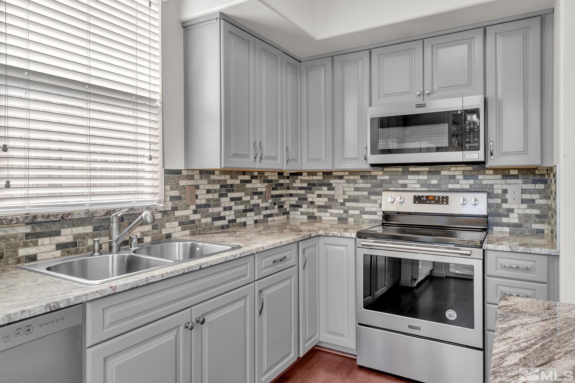 9266 Running Dog Circle Reno, NV 89506 - Photo 11 of 35 a kitchen with granite countertop a sink stove and microwave