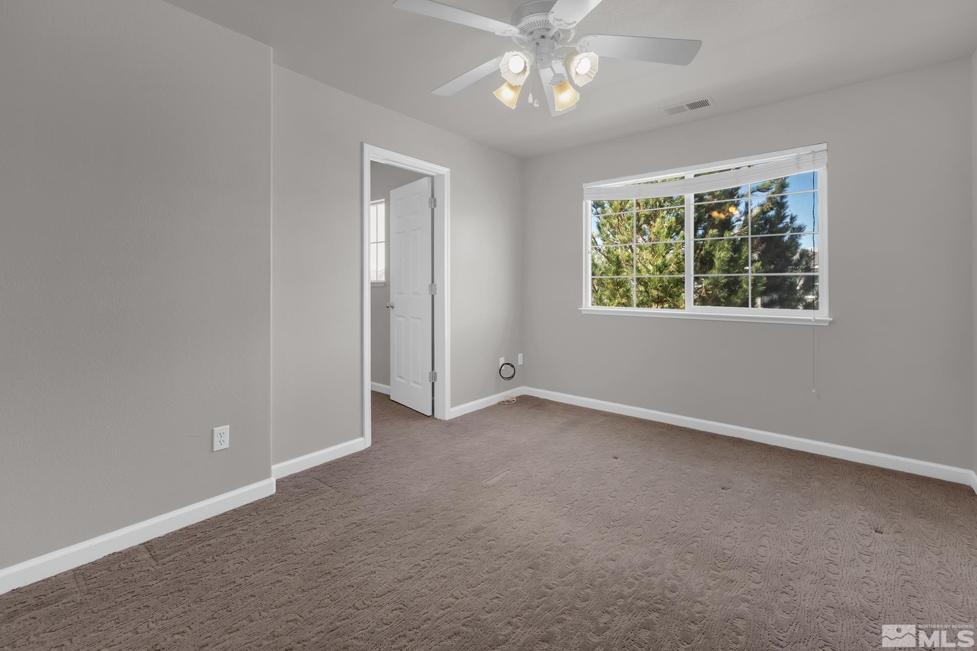 9266 Running Dog Circle Reno, NV 89506 - Photo 23 of 35 an empty room with chandelier fan and windows
