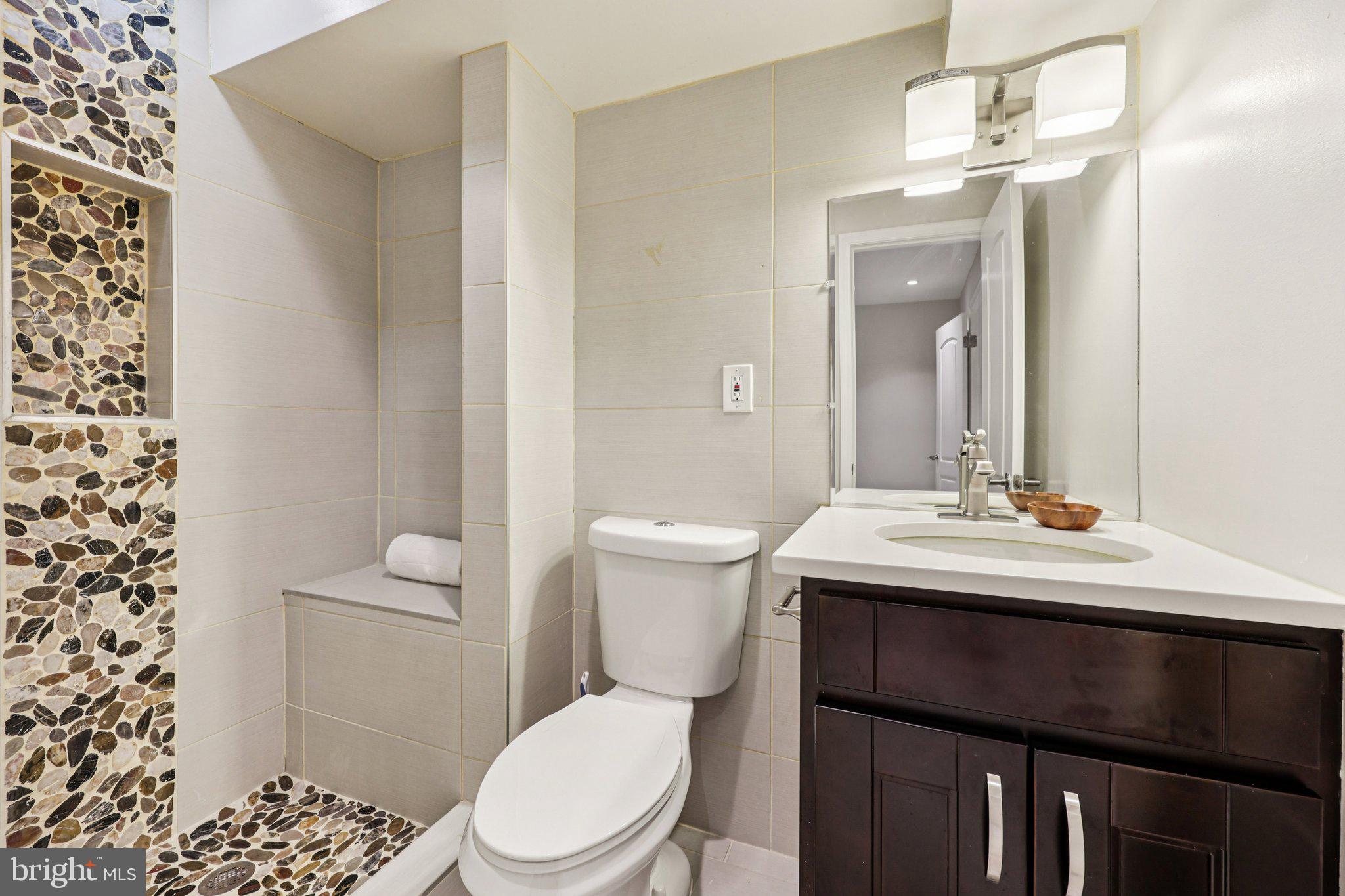 5209 5th Street Northwest Washington, DC 20011 - Photo 24 of 38 a bathroom with a sink a toilet a mirror and shower