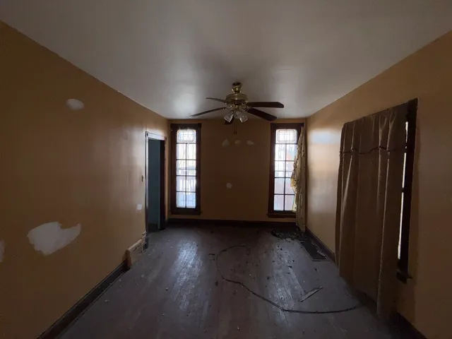 wooden floor in an empty room with a window