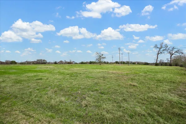 a view of a big yard with lots of green space