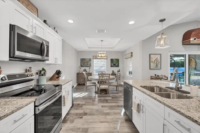a large kitchen with stainless steel appliances granite countertop a lot of counter space and a sink
