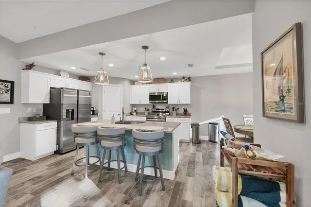 a kitchen with a dining table chairs stove and cabinets