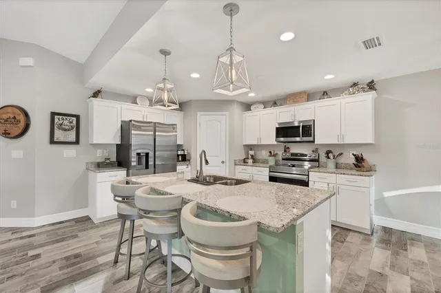 a kitchen with sink a microwave and cabinets