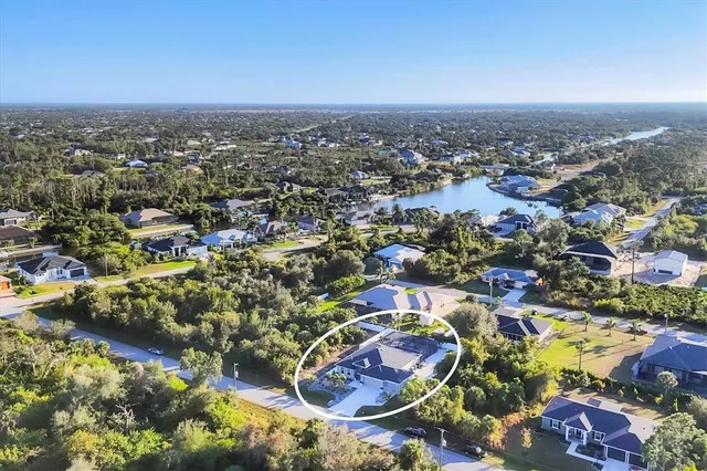 an aerial view of residential houses with outdoor space and trees