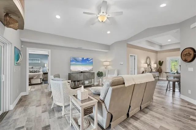 a living room with furniture a clock and a flat screen tv