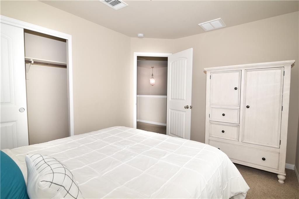 18405 Congaree Street Pflugerville, TX 78660 - Photo 13 of 26 a large white bed in a white room with closet and dresser