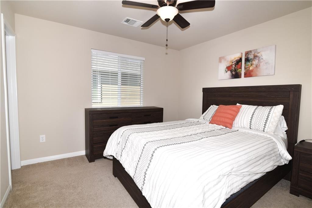 18405 Congaree Street Pflugerville, TX 78660 - Photo 14 of 26 a bedroom with a bed and a chandelier