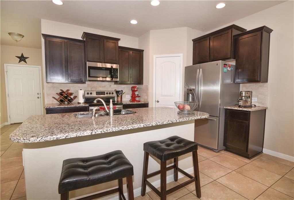 18405 Congaree Street Pflugerville, TX 78660 - Photo 8 of 26 a kitchen with stainless steel appliances granite countertop a sink refrigerator and microwave