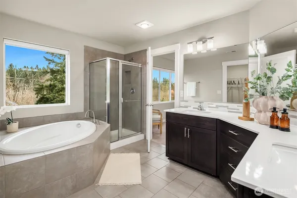 a spacious bathroom with a tub sink shower and mirror