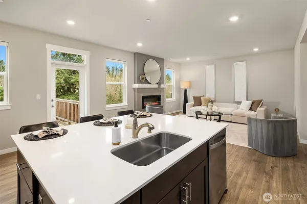 a kitchen with a sink a stove and wooden floor