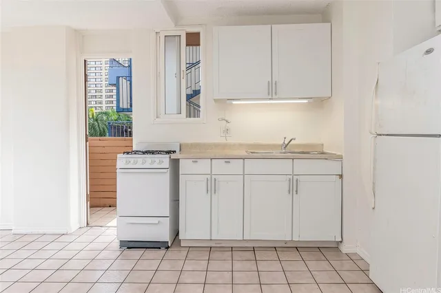 a kitchen with white cabinets and white appliances