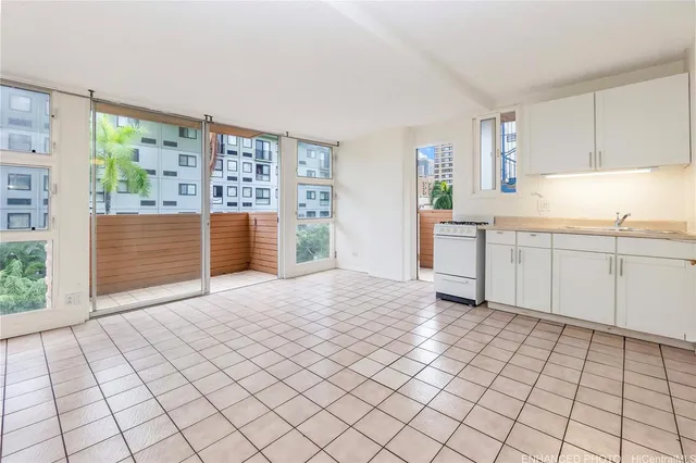 a view of empty room with window and cabinet