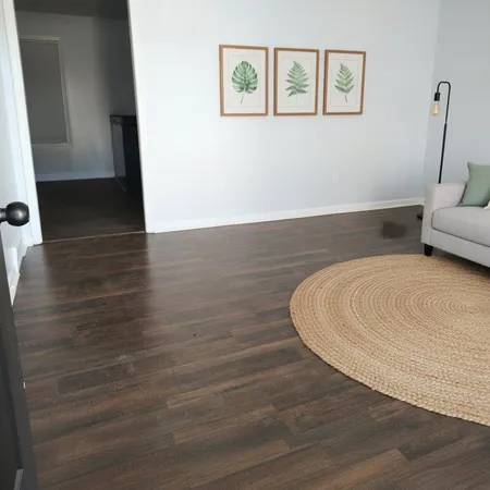 a view of a hallway with wooden floor and furniture