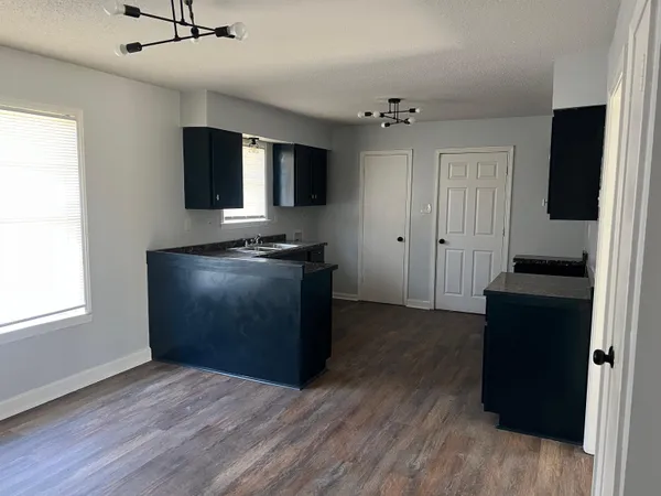 a view of a kitchen with wooden floor and a ceiling fan