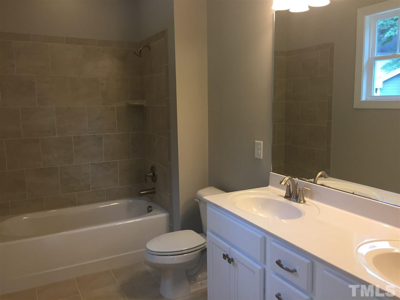 1076 Mills Street Raleigh, NC 27608 - Photo 13 of 16 a bathroom with a sink a toilet and bathtub