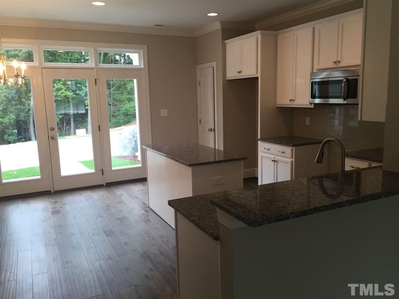 1076 Mills Street Raleigh, NC 27608 - Photo 7 of 16 a kitchen with stainless steel appliances granite countertop a sink a microwave a refrigerator and white cabinets