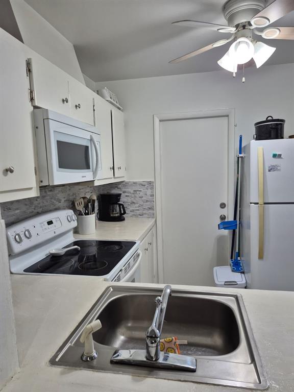 560 Southeast 2nd Avenue, Unit H2 Deerfield Beach, FL 33441 - Photo 14 of 23 a kitchen with a sink a microwave and cabinets