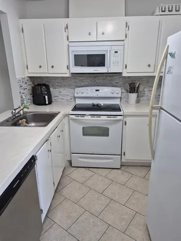a kitchen with cabinets appliances and a sink