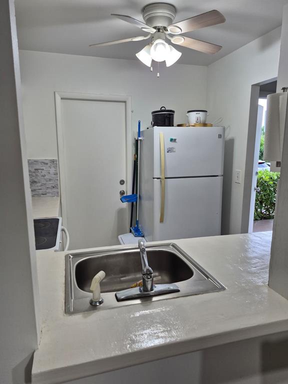 560 Southeast 2nd Avenue, Unit H2 Deerfield Beach, FL 33441 - Photo 7 of 23 a kitchen with a refrigerator and a sink
