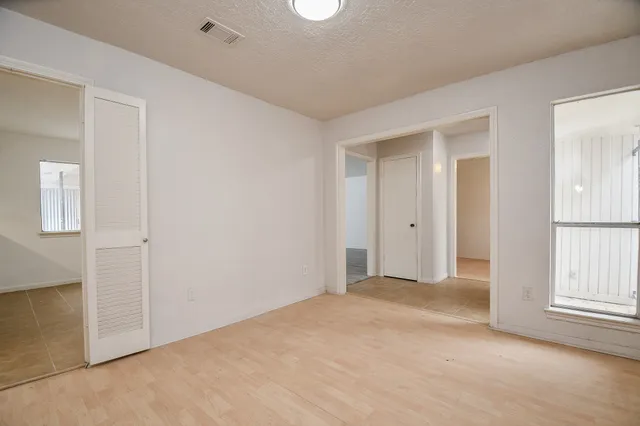 an empty room with windows and closet