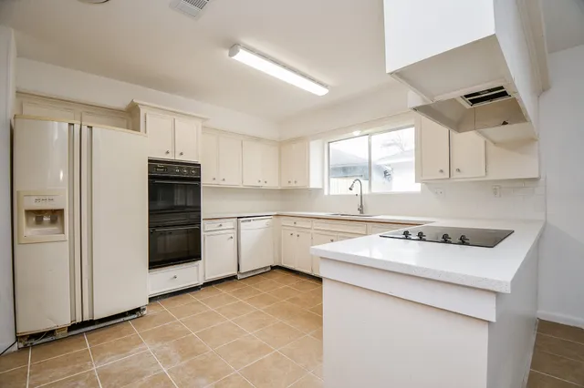 a kitchen with a sink a stove a refrigerator and cabinets