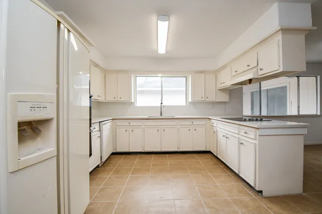 a kitchen with granite countertop white cabinets and white appliances