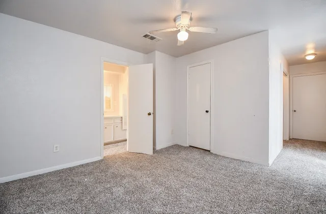 an empty room with windows and fan