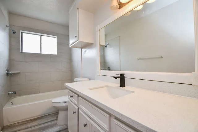 a bathroom with a sink a toilet and bathtub