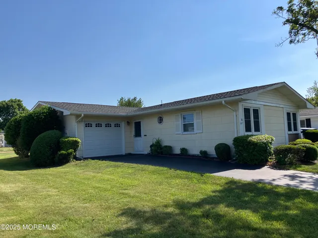 a front view of a house with a garden and plants