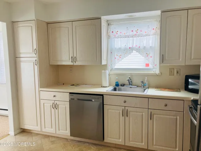 a kitchen with white cabinets and sink