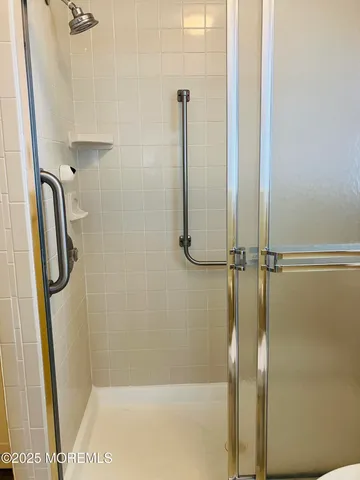a white toilet sitting next to a shower