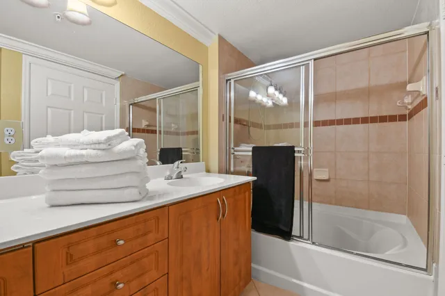 a bathroom with a granite countertop sink mirror and bathtub
