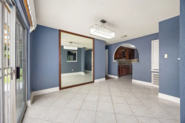 a view of a kitchen with a sink and an empty room
