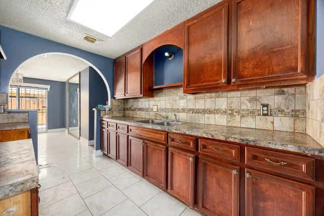 a kitchen with granite countertop a sink and cabinets