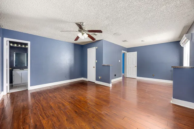 a view of an empty room with wooden floor
