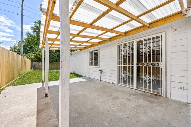 a view of a house with a small yard and wooden fence