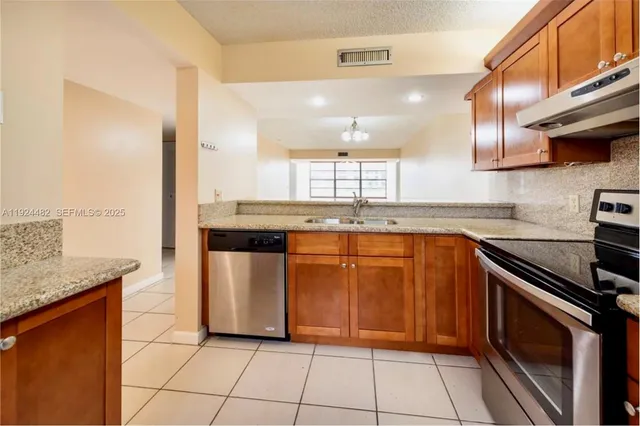 a kitchen with stainless steel appliances granite countertop a sink stove and cabinets