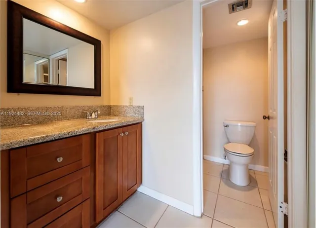 a bathroom with a toilet a sink and mirror
