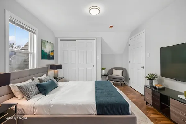 a bedroom with a large bed and a flat screen tv