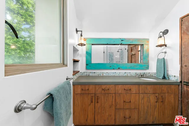 a bathroom with a granite countertop sink and a mirror