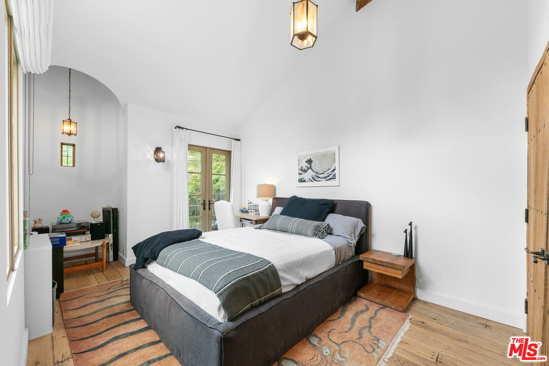 24920 Malibu Road Malibu, CA 90265 - Photo 26 of 49 a bedroom with a bed and wooden floor