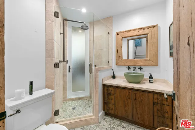 a bathroom with double vanity sink a mirror a bathtub and shower