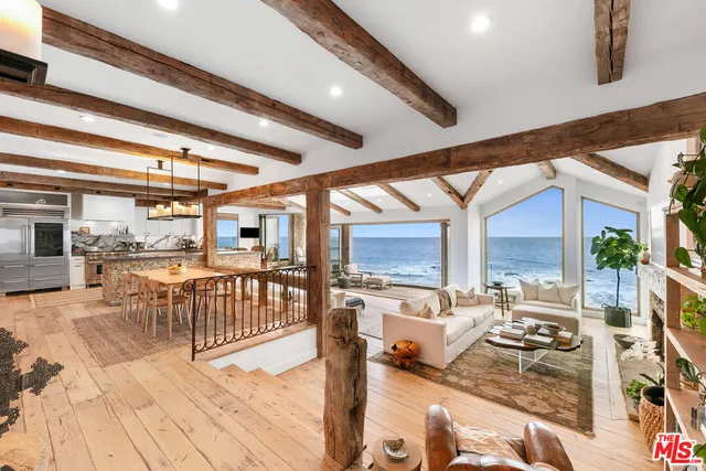 a dining hall with stainless steel appliances granite countertop a stove and white cabinets