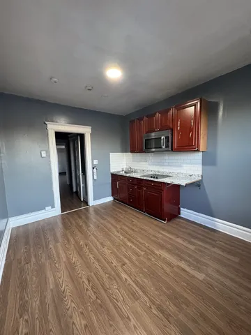 a large kitchen with granite countertop wooden cabinets and a wooden floor