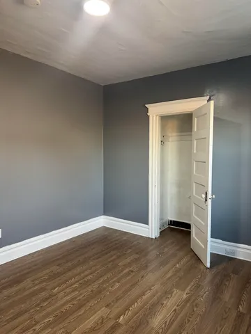 an empty room with wooden floor & closet