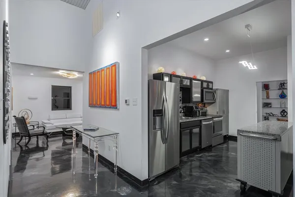 a kitchen with refrigerator and chairs