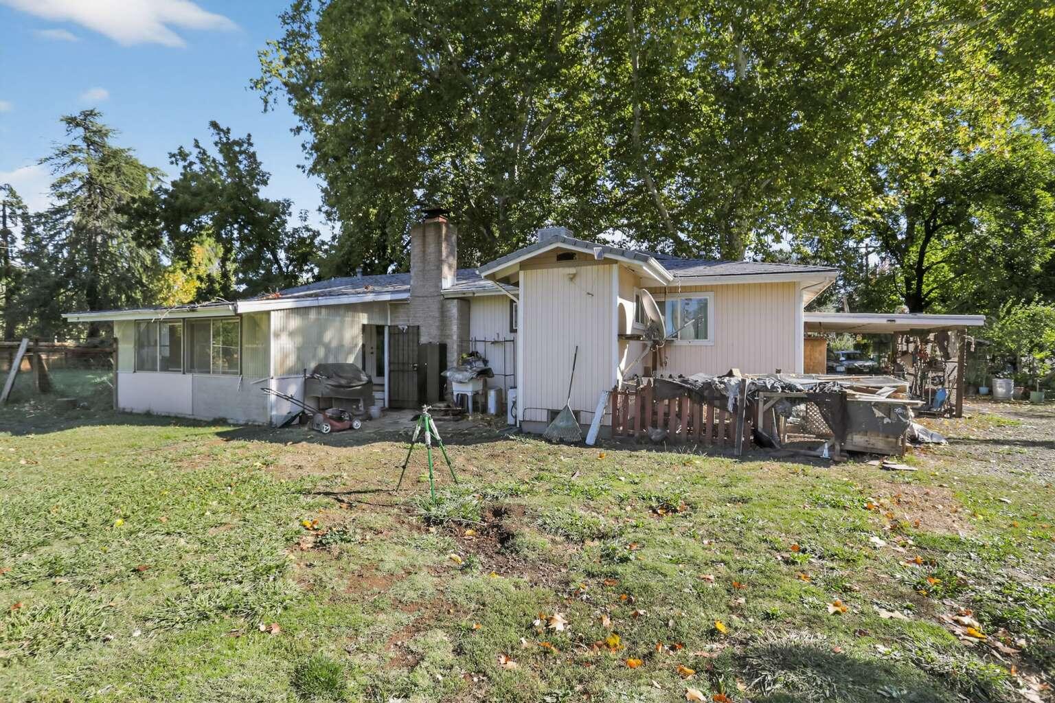 7408 Bridge Lane Redding, CA 96002 - Photo 25 of 25 a view of a backyard with table and chairs and couches under an umbrella